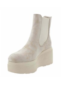 Botín de ante beige con paneles laterales elásticos, punta redondeada y una suela gruesa con plataforma. Textura suave con patrones sutiles en la superficie.