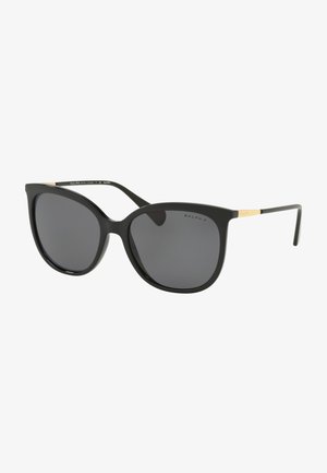 Black oversized sunglasses with dark lenses, a smooth plastic frame, and gold accents on the temples. Stylish cat-eye shape.