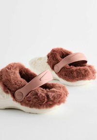 Pantofole in finta pelliccia marrone con suola bianco cremoso, dotate di cinturini regolabili rosa e una parte superiore texturizzata per il massimo comfort.