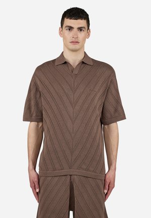 Brown knitted polo shirt featuring a textured zigzag pattern, short sleeves, and a polo collar. The fabric is lightweight and ribbed.