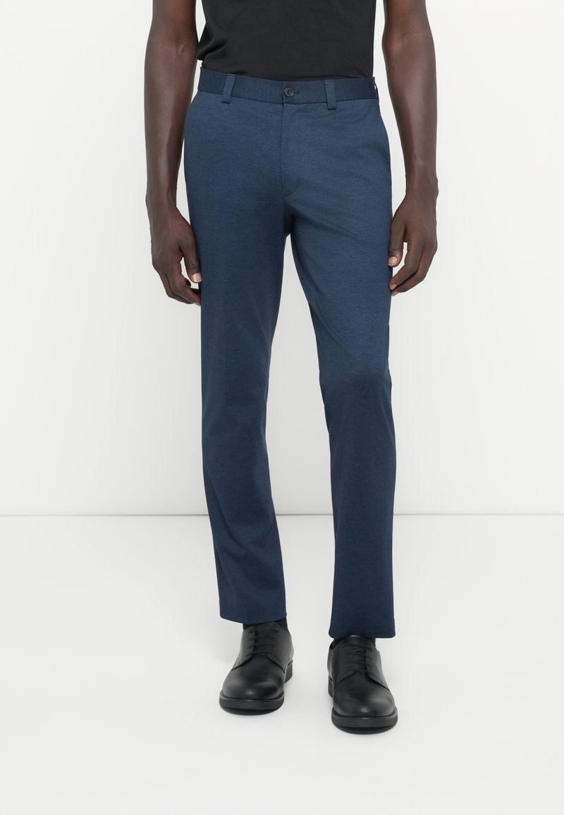 Pantalon bleu marine pour homme en tissu texturé et extensible. Caractérisé par une taille standard avec une fermeture à bouton et un design à devant plat.