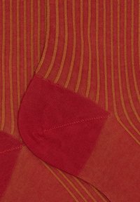 Calzini a righe rosse con linee gialle, dalla texture liscia e con tallone e punta rinforzati per una maggiore durata.