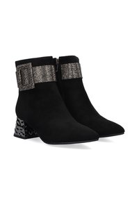 Botas negras de tobillo en ante con un cierre metálico brillante en el tobillo. Presentan un tacón de bloque estampado y un diseño de punta afilada.