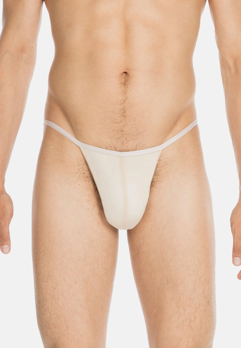 Beige Tangas aus einem glatten, elastischen Stoff. Dünne elastische Träger an den Seiten. Nähte sind entlang der Vorderpartie sichtbar.