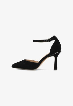 Chaussure en cuir suédé noir à talon haut avec un bout pointu, une bride à la cheville et un talon fin. Présente un design découpé à l'arrière et un intérieur lisse.