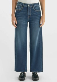 Donkerblauwe, brede spijkerbroek van denim met een soepele textuur; heeft vijf zakken, een knoopsluiting en contrasterende stikdetails.