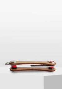 Trä multi-tool med en böjd design, metalliska accenter, röda och silverdetaljer, samt en kompakt storlek för portabilitet. Har en kniv och skruvmejslar.