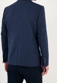 Mörkblå blazer med texturerad tyg, enkel vent bak och fyra knappar på varje ärm. Skräddarsydd passform med strukturerade axlar.