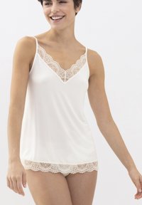 Witte camisole met delicate kanten rand langs de V-halslijn en zoom, met dunne verstelbare bandjes en een gladde textuur.