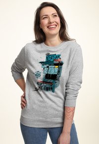 Sudadera gris con un gráfico colorido de un edificio estilizado. Puños y dobladillo acanalados, corte holgado, material suave de mezcla de algodón.