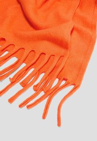 Écharpe orange vif en tissu doux, avec des bords frangés et une texture lisse, drapée dans une disposition lâche.