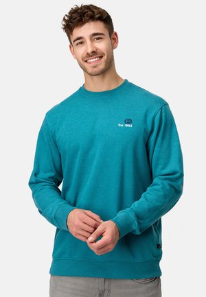 Teal sweatshirts, van een katoenmix, ronde hals, ribgebreide manchetten en onderrand. Logo op de linkerborst met "Est. 1993" in wit en donkerblauwe stiksels.