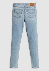 Jeans en denim bleu clair vus de dos avec deux poches cousues, passants de ceinture et une étiquette de marque en cuir marron sur la ceinture.