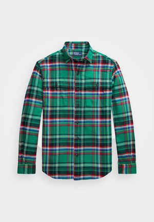 Camisa de cuadros verdes con botones, con detalles en negro y rojo, cuenta con dos bolsillos en el pecho y mangas largas, fabricada en tela de franela.