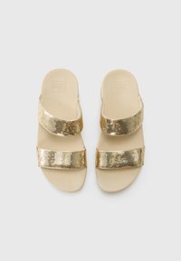 Gullige sequin sklidesandaler med to brede stropper, blødt beige fodseng, flad sål og afrundede kanter. Simpelt design, tekstureret overdel.