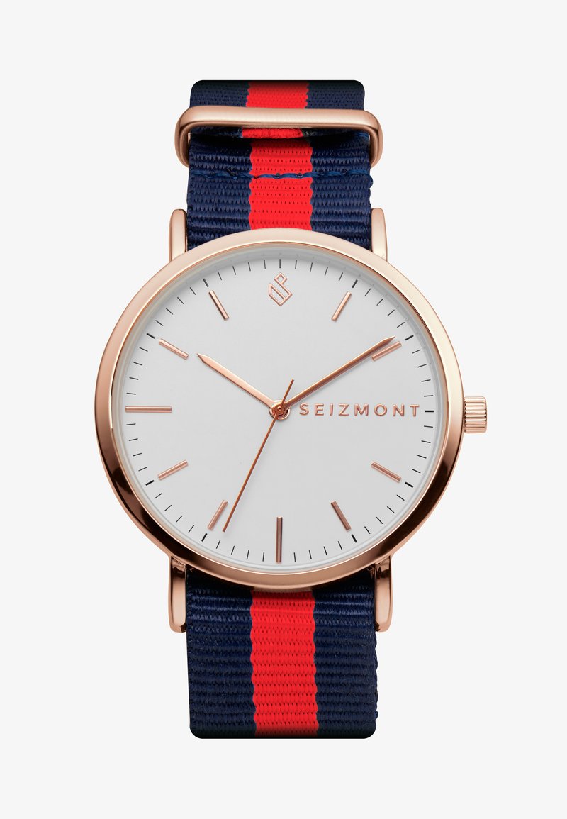 Rosa gull klokke med hvit urskive, med slanke timemarkører. Sammen med et tekstilarmbånd i marineblått med røde striper.