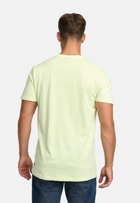 Light green short-sleeve t-shirt made from soft fabric, with a crew neck and a straight hem. Features a minimalistic design.