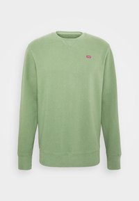 Grön sweatshirt av mjukt tyg med rund hals, långa ärmar och en liten röd Levi's-logotyp på bröstet.
