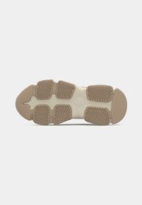 Sole of athletic shoe with a textured brown rubber base. Features patterned ridges for traction and a smooth, flexible beige midsole.