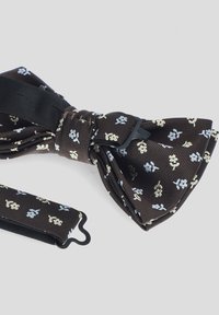 Brązowy pleciony muszka z kwiatowym wzorem w jasnoniebieskim i złotym kolorze. Posiada czarny regulowany pasek do zapinania.