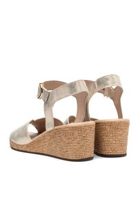 Korkové sandály v metalické zlaté barvě s texturovaným koženým svrškem, otevřenou špičkou, pásem kolem kotníku a tkaným jutovým detailem na podpatku.