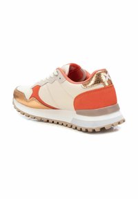 Zapatillas con un tono crema en la parte superior, acentos naranjas y detalles en cobre metálico. Suela texturizada para tracción, con lengüeta y cuello acolchados.