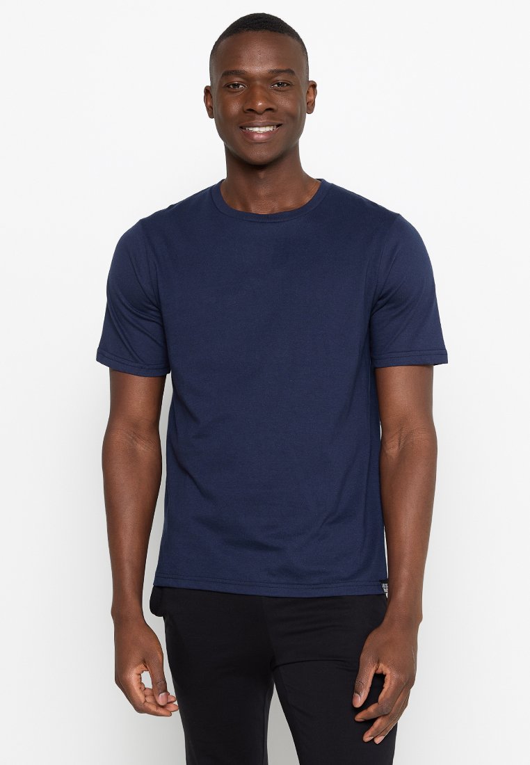 T-shirt en coton bleu marine à manches courtes, col rond et coupe décontractée. Texture lisse, sans motifs ni logos visibles.