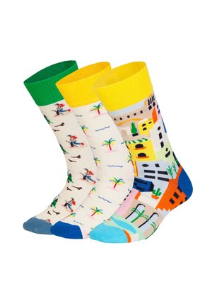 Tre farverige mellemlange sokker med forskellige mønstre: en med grøn kant og motiv af en gående person, en med palmer og bølger, og en med bylandskab.