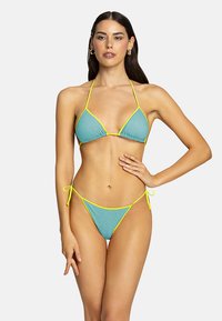 Set bikini turchese con accenti giallo neon. Presenta un top triangolare con sottili lacci e slip a vita bassa con cinturini laterali regolabili.