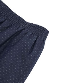 Pantaloni corti di tessuto blu navy con motivo a pois, caratterizzati da una vita elasticizzata e una texture liscia. Cuciture laterali visibili lungo la cucitura.