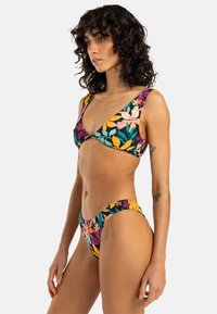 Blommig bikini i livliga färger, med en triangulär topp med breda axelband och matchande lågt skurna bottnar. Sträckbart, mjukt tyg.