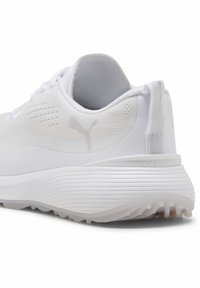 Hvid atletiksko med en tekstureret overdel, afrundet sål og fremtrædende mærkelogo. Har en træktap bagpå og glatte detaljer.