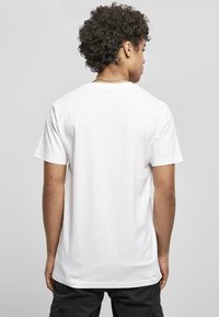 Hvid bomulds t-shirt med korte �ærmer, rund hals, glat tekstur og en afslappet pasform, vist fra ryggen.
