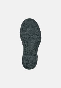 Schwarze Gummisohle mit strukturierten Oberflächen und Profilmuster. Verfügt über ein zentrales Logo und geprägte Details in der Nähe der Ferse.