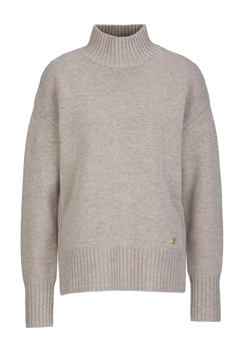 Lichtbeige coltrui gemaakt van zacht breimateriaal. Heeft ribbels aan de mouwen en onderkant, met een klein metallic logo accent aan de zijkant.