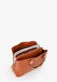 Borsa a mano in pelle marrone con finitura texturizzata, dotata di manico in bambù e molteplici scomparti, inclusa una tasca con zip e chiusure a pressione.