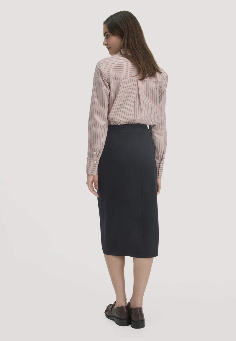 Gestreiftes, hellrosa Langarmhemd kombiniert mit einem hoch taillierten, dunkelblauen Bleistiftrock. Verfügt über einen glatten, strukturierten Stoff und einen klassischen Schnitt.