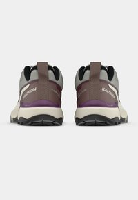 Παπούτσια πεζοπορίας Salomon σε γκρι και μωβ, με επάνω μέρος από δίχτυ, λαστιχένιες σόλες, υφασμένο τακούνι και αντανακλαστικές λεπτομέρειες. Εμφανίζεται η πίσω όψη.