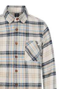 Geruite flanellen shirt in crème, blauw en bruin tinten. Bevat een knoopsluiting kraag, houten knopen en een borstzak met een label.
