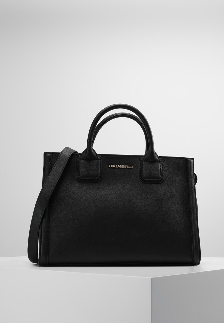 Musta nahkarepussa on kaksi yläkahvaa ja irrotettava olkahihna. Sen pinta on sileä ja siinä on kullanvärinen logo. Muoto on suorakulmainen.