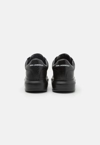 Sneaker nere con una finitura testurizzata e pannelli lisci, caratterizzati da una suola rialzata e dal logo "KARL LAGERFELD" sul tallone.