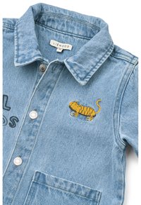 Τζιν μπουφάν σε ανοιχτό μπλε με γιακά, μπροστινά κουμπιά και κεντημένο κίτρινο σχέδιο τίγρης. Φέρει κείμενο «real friends» σε μαύρο.