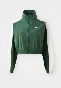Veste verte courte avec un col montant, des manches blanches contrastantes, une fermeture éclair et une taille élastique. Logo Nike sur la poitrine.