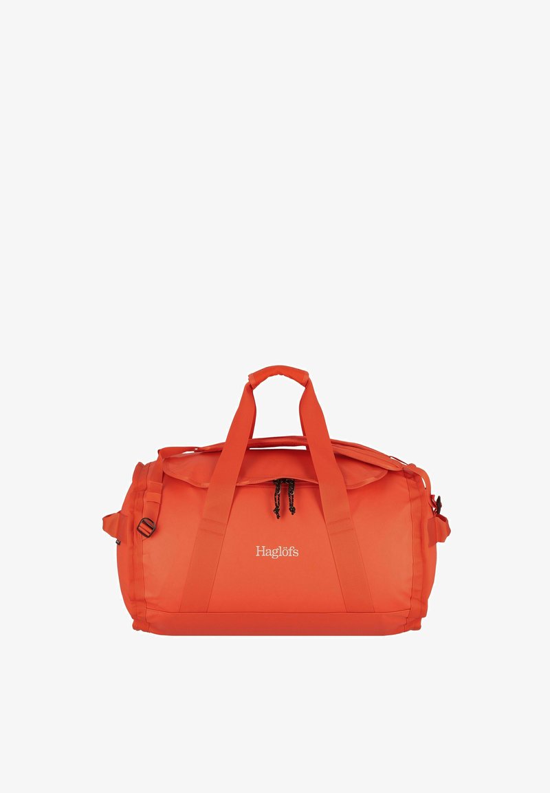 Rote Reisetasche aus strapazierfähigem, glattem Material. Verfügt über doppelte Griffe, einen verstellbaren Schultergurt, einen Reißverschluss und ein Logo auf der Vorderseite.