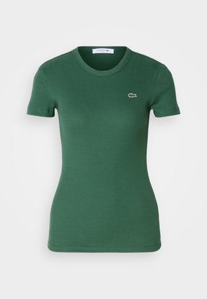Grünes, geripptes T-Shirt mit kurzen Ärmeln, rundem Halsausschnitt und einem kleinen gestickten Krokodil-Logo auf der linken Brust.