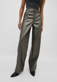 Pantalons larges en simili cuir métallisé vert avec une texture lisse, dotés de poches avant, d'une fermeture à bouton et d'accents de couture.
