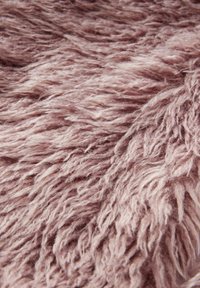 Textuur, luchtige stof in zachte mauve kleur, met lange, golvende vezels en een pluizige uitstraling. Ideaal voor meubelbekleding of woningdecoratie.