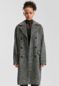 Grijs en zwart geblokt wollen jasje, dubbelzijdig met grote knopen, brede kraag, zijzakken en een gestructureerde stof met een houndstooth-patroon.