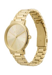 Reloj analógico dorado con esfera redonda, esfera minimalista y pulsera de cadena tono dorado. Presenta una textura suave y marcadores de hora simples.