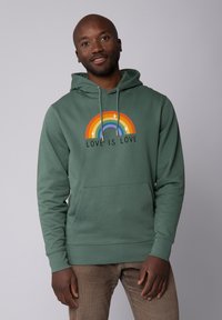 Groene hoodie met een regenboogafbeelding en de tekst "LOVE IS LOVE," trekkoorden en een voorzak. Soepele textuur.